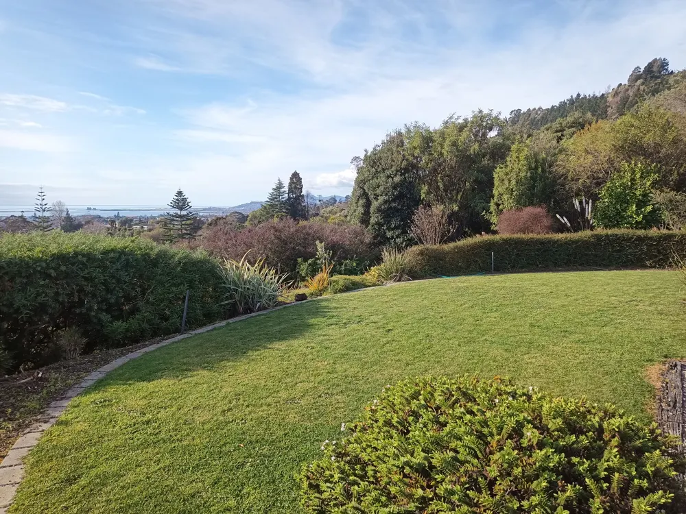 A mown lawn and trimmed hedges with a view over Tasman